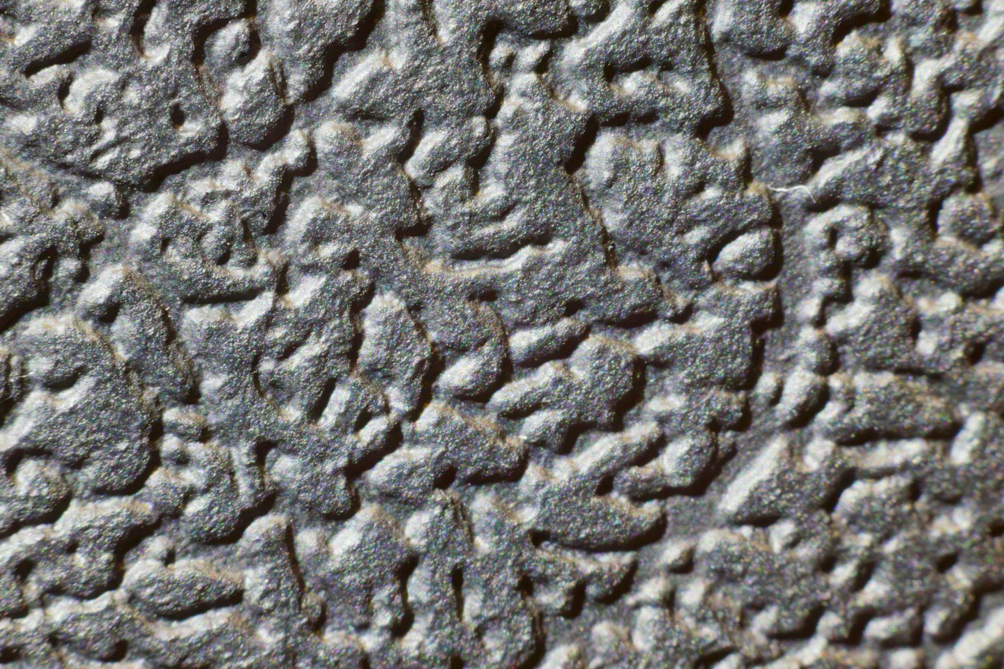 Dark grey textured material with a raised bumpy pattern.