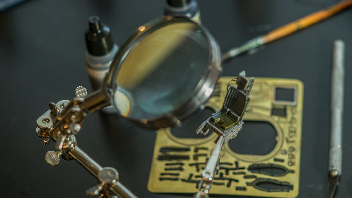 Hobbyist assembling a detailed model airplane cockpit.